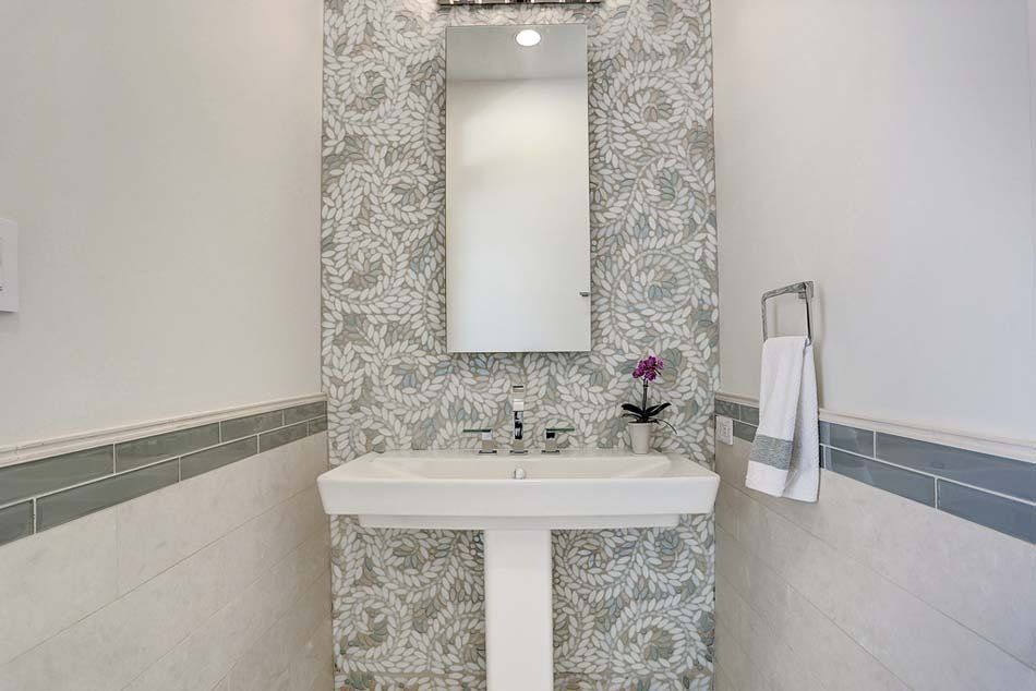 A bathroom with a sink , mirror and towel rack.
