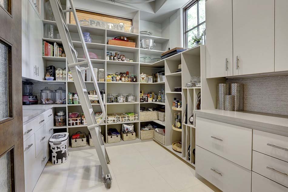A kitchen with a pantry and a ladder leading up to it.