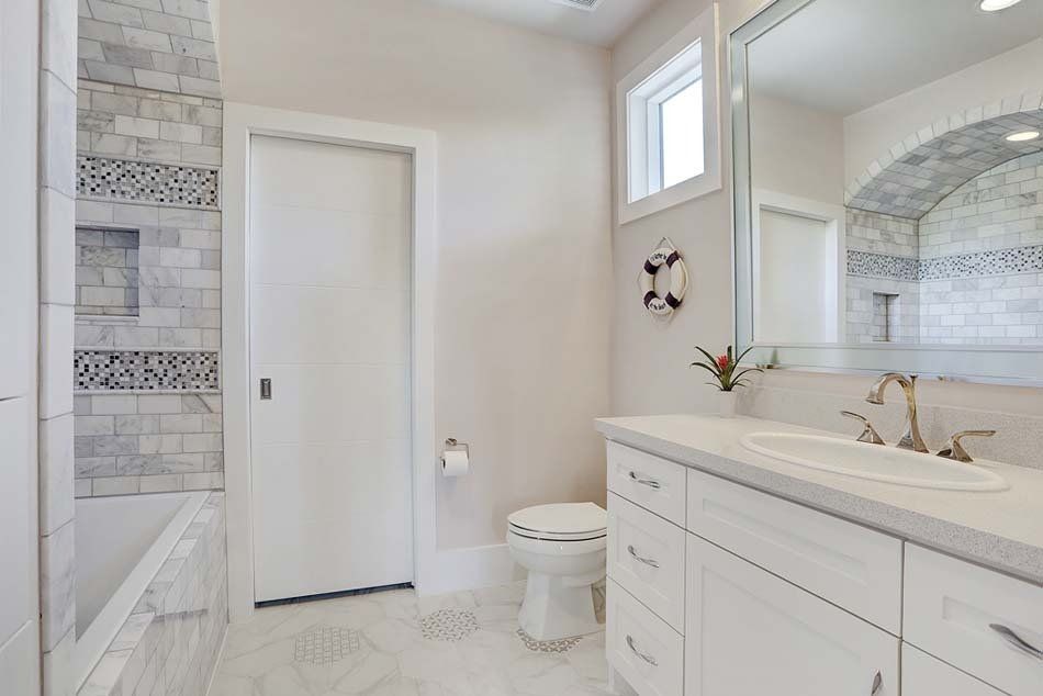 A bathroom with a toilet , sink , and mirror.