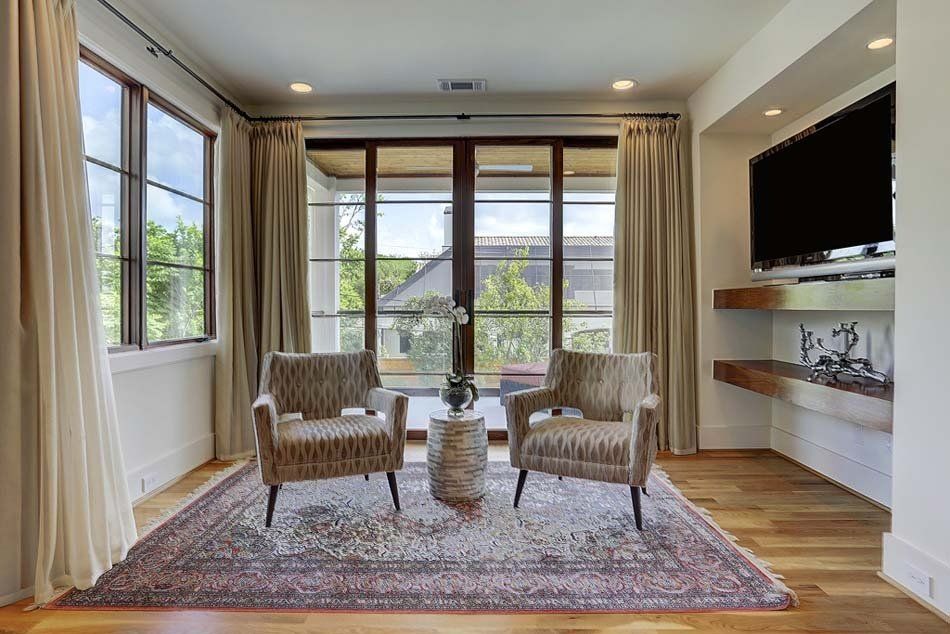 A living room with two chairs and a television.