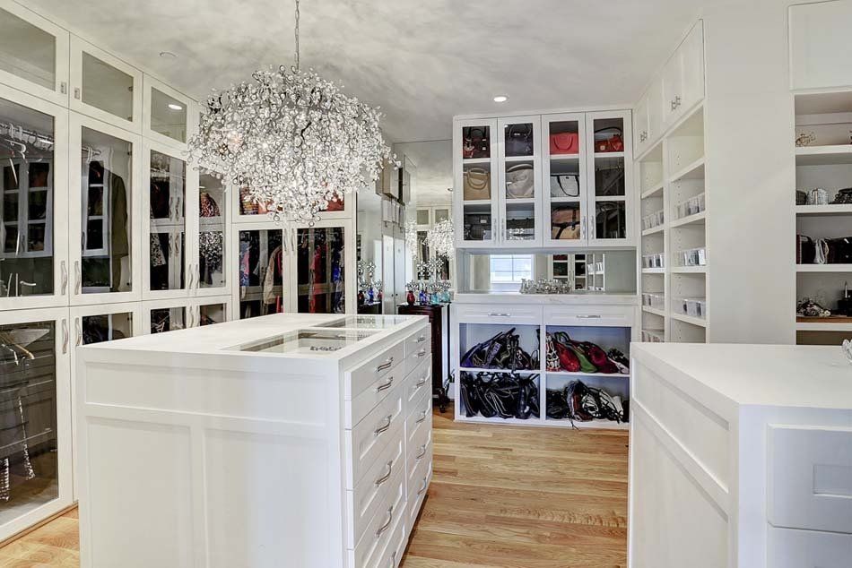 A large walk in closet filled with lots of clothes and shoes.