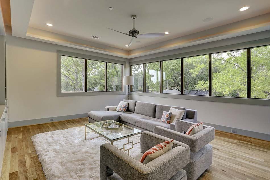 A living room with a couch , chairs , and a ceiling fan.