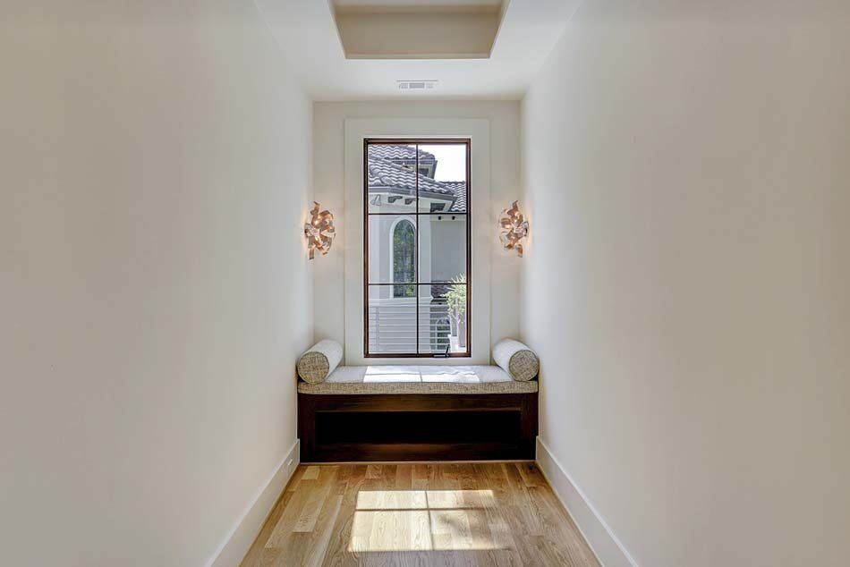 There is a window seat in the middle of the hallway.