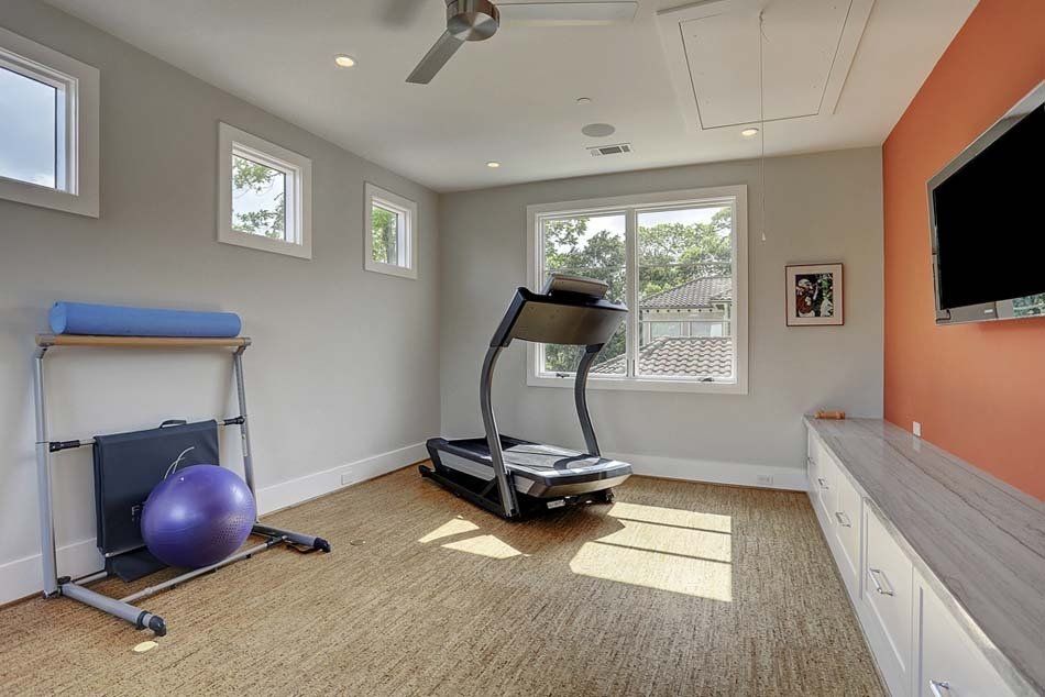 A home gym with a treadmill and a television