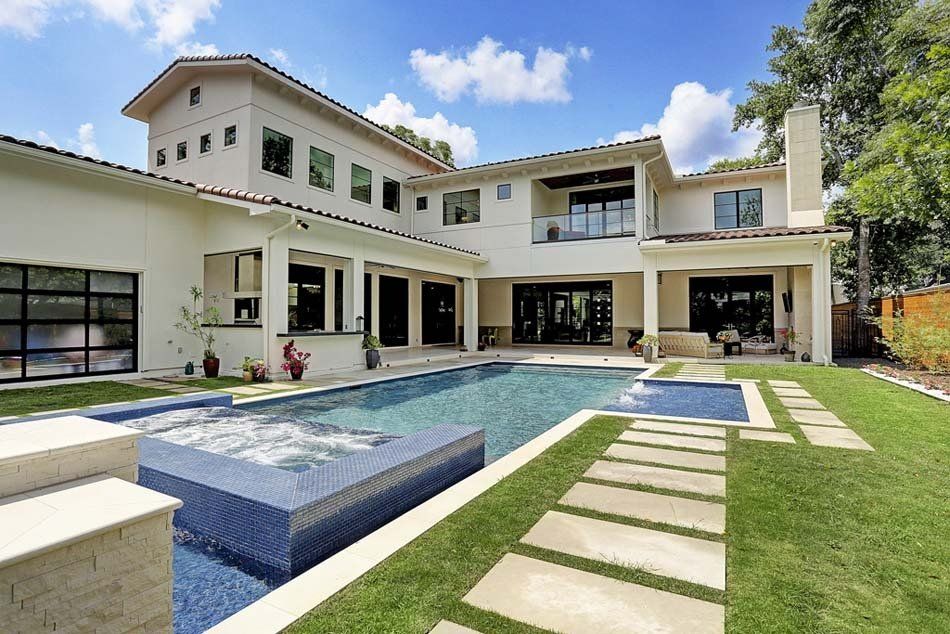 A large white house with a large swimming pool in the backyard