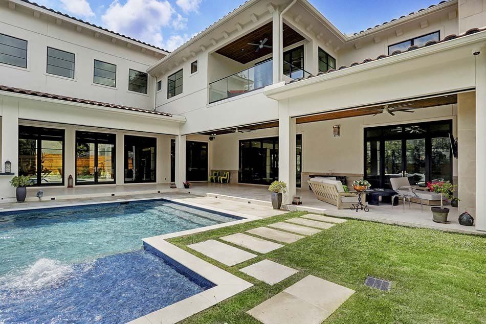 A large white house with a large swimming pool in the backyard.