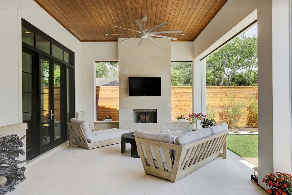 A living room with a fireplace , couch , television and ceiling fan.