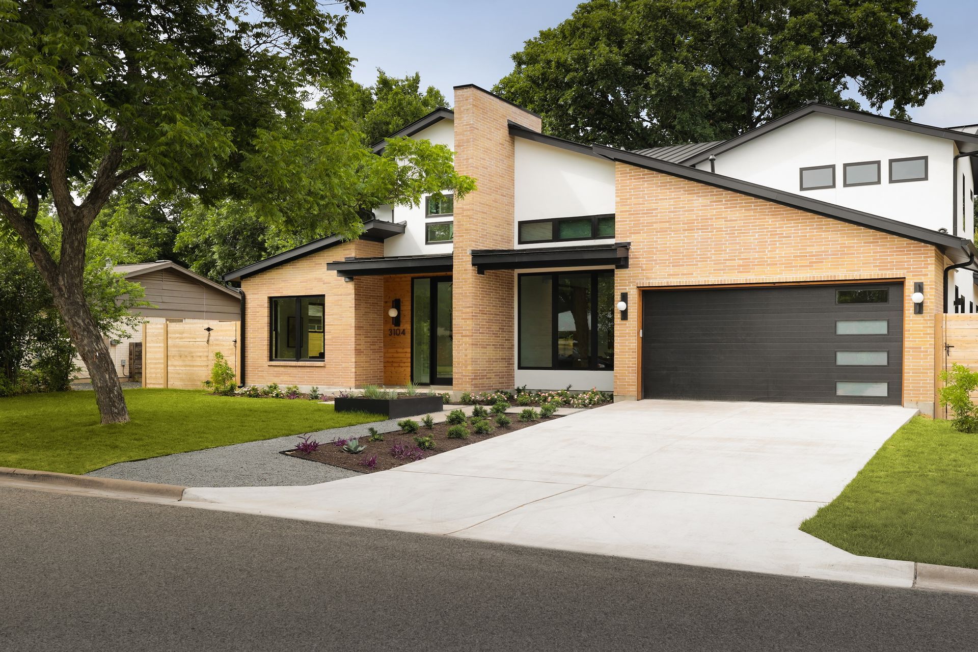 A modern house with a brick facade and a black garage door
