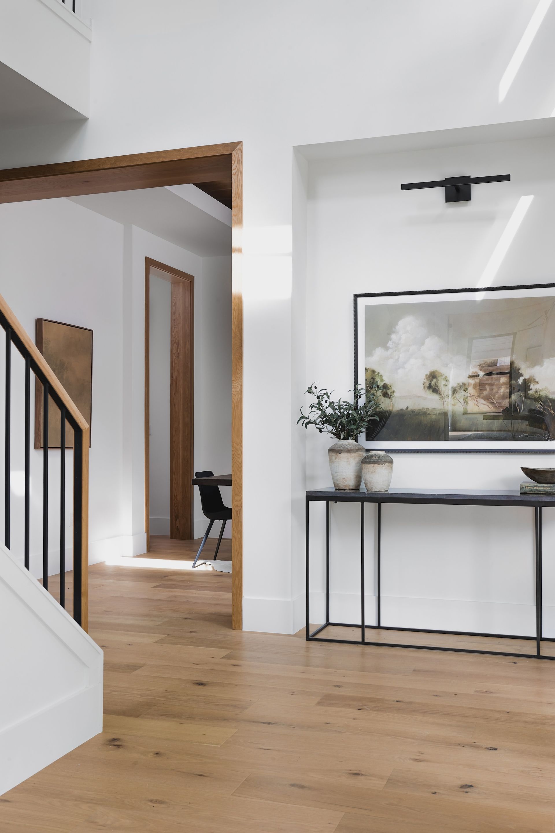 A hallway with a table and a picture on the wall