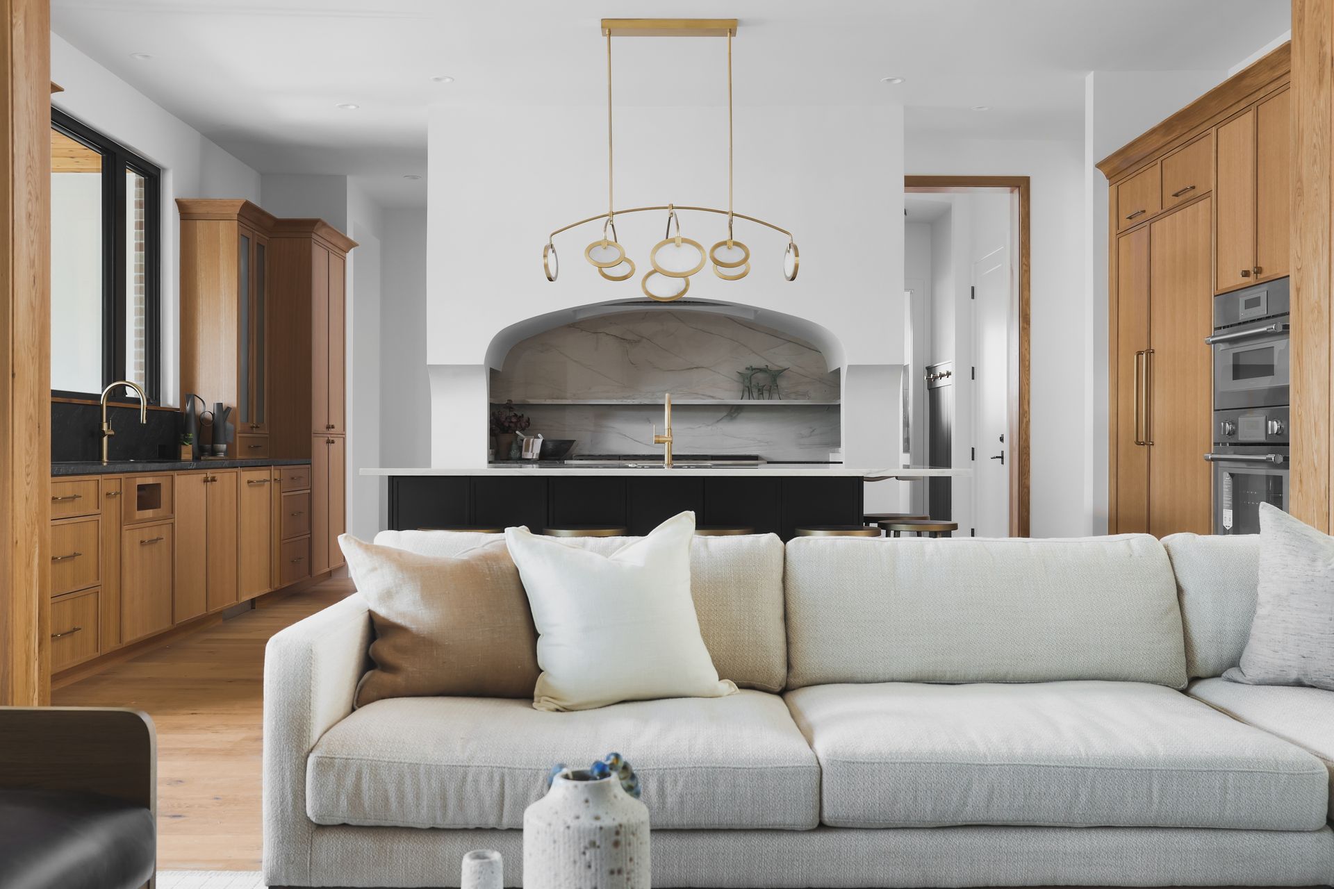 A living room with a couch and a kitchen in the background.