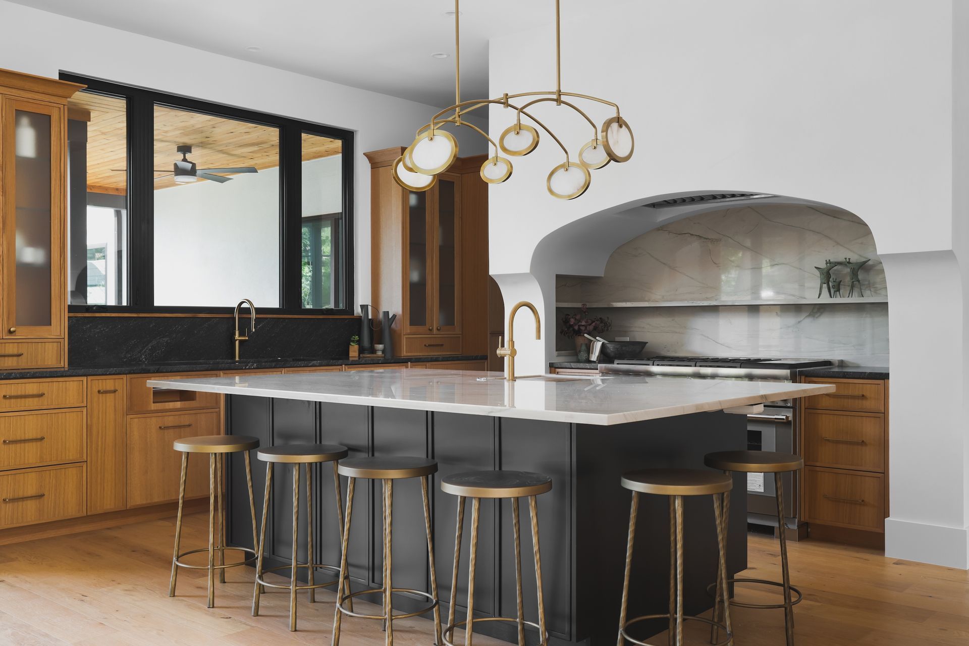 A kitchen with a large island and stools.