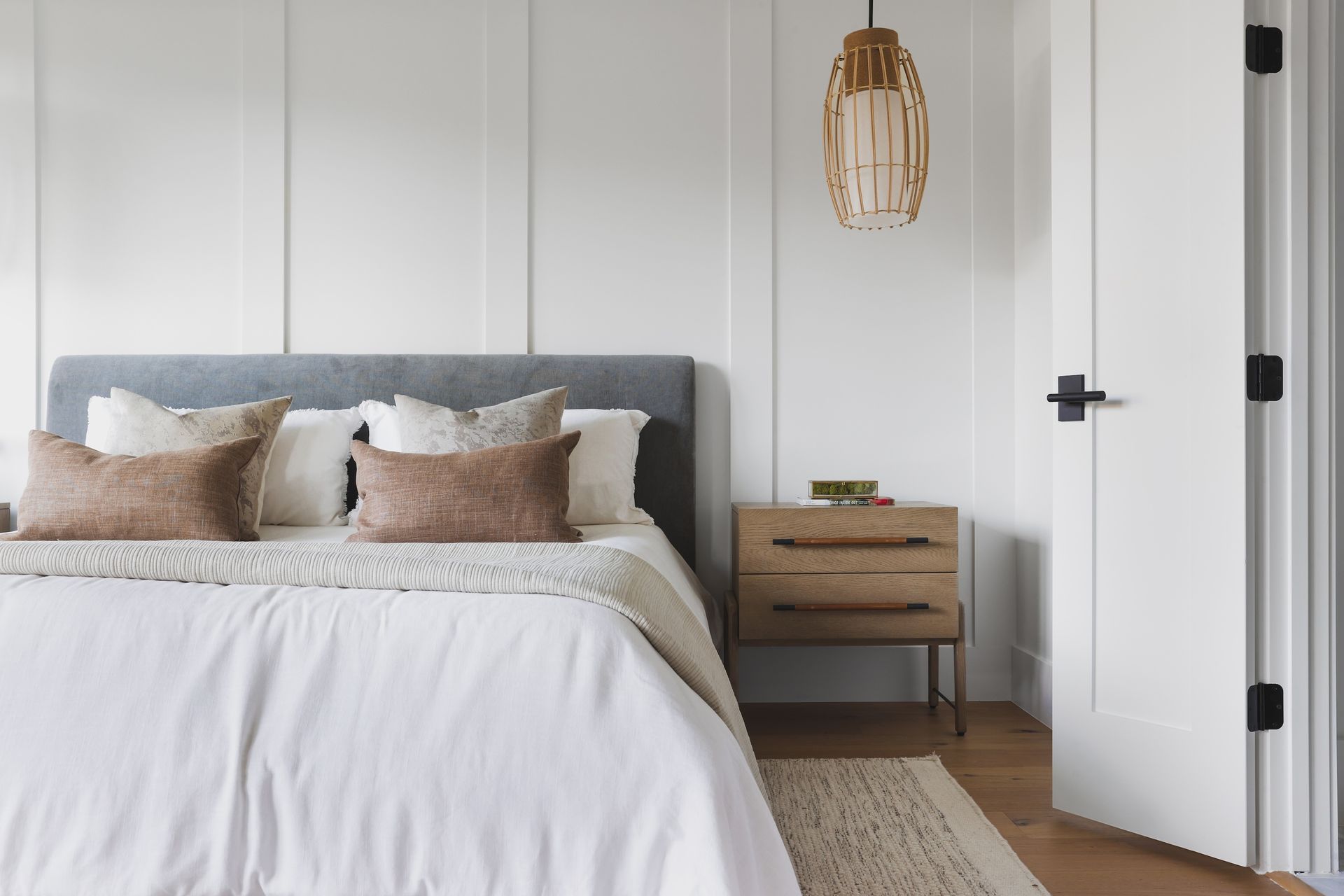 A bedroom with a bed , nightstand , and white walls.