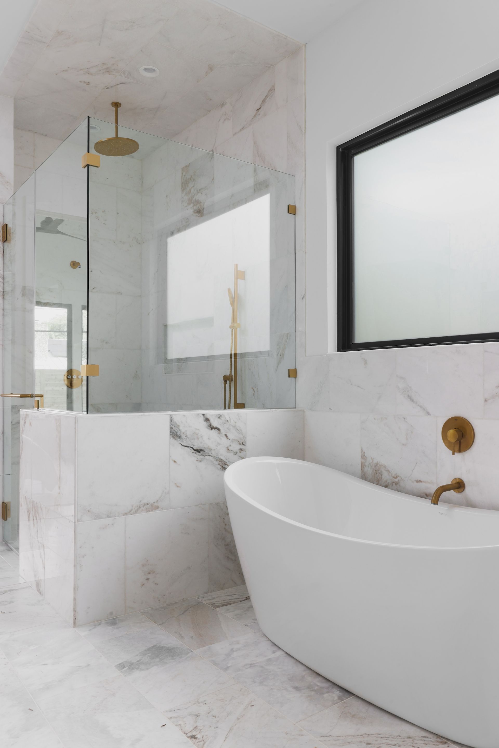 A bathroom with a bathtub , sink , shower and mirror.