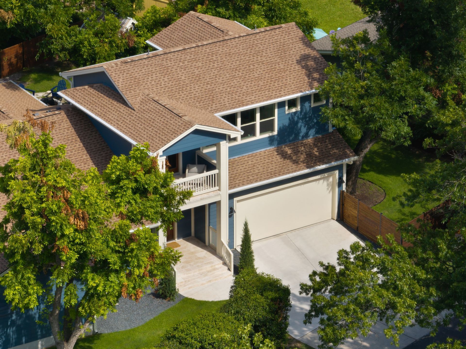 An aerial view of a blue house with a brown roof
