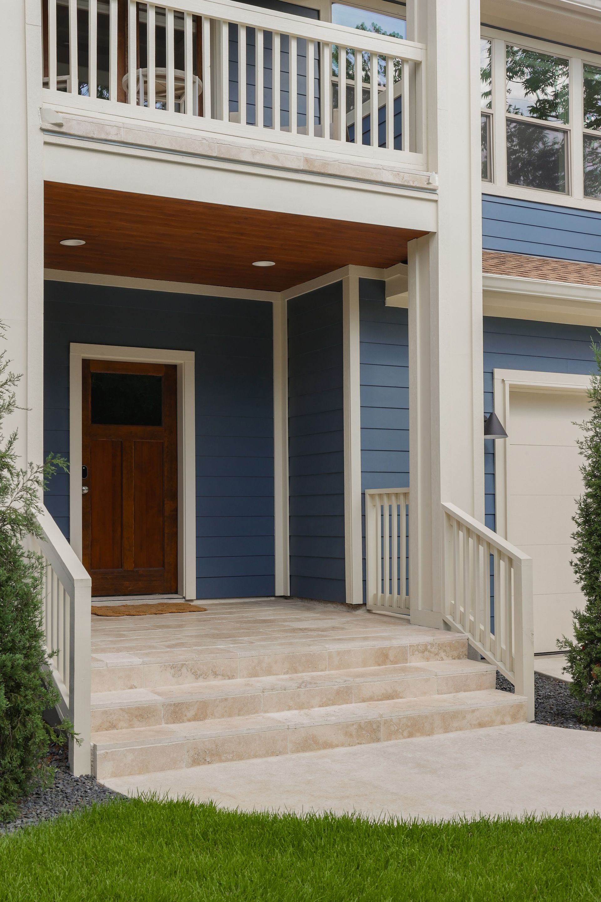 A blue and white house with a porch and stairs