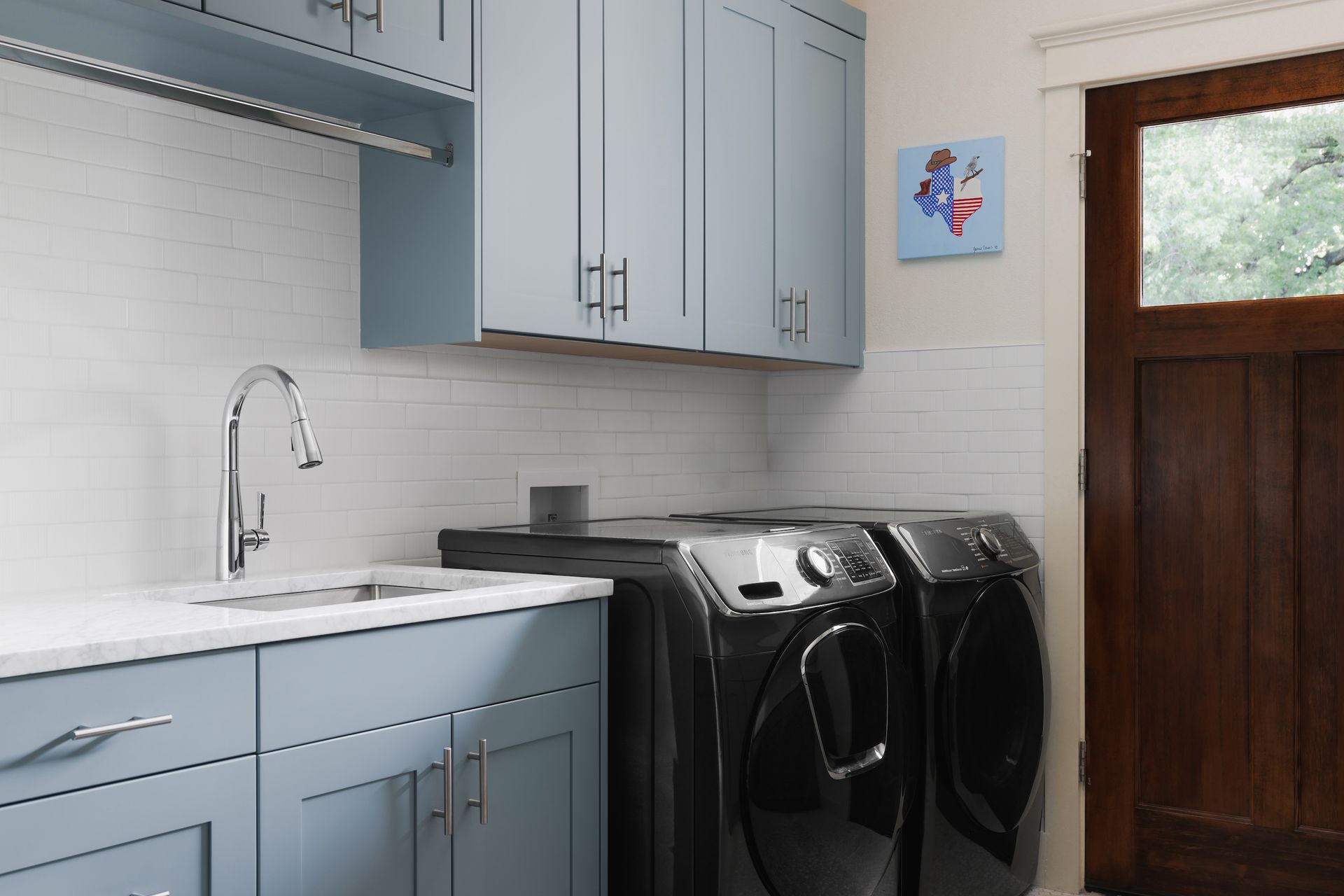A laundry room with a washer and dryer and a sink.