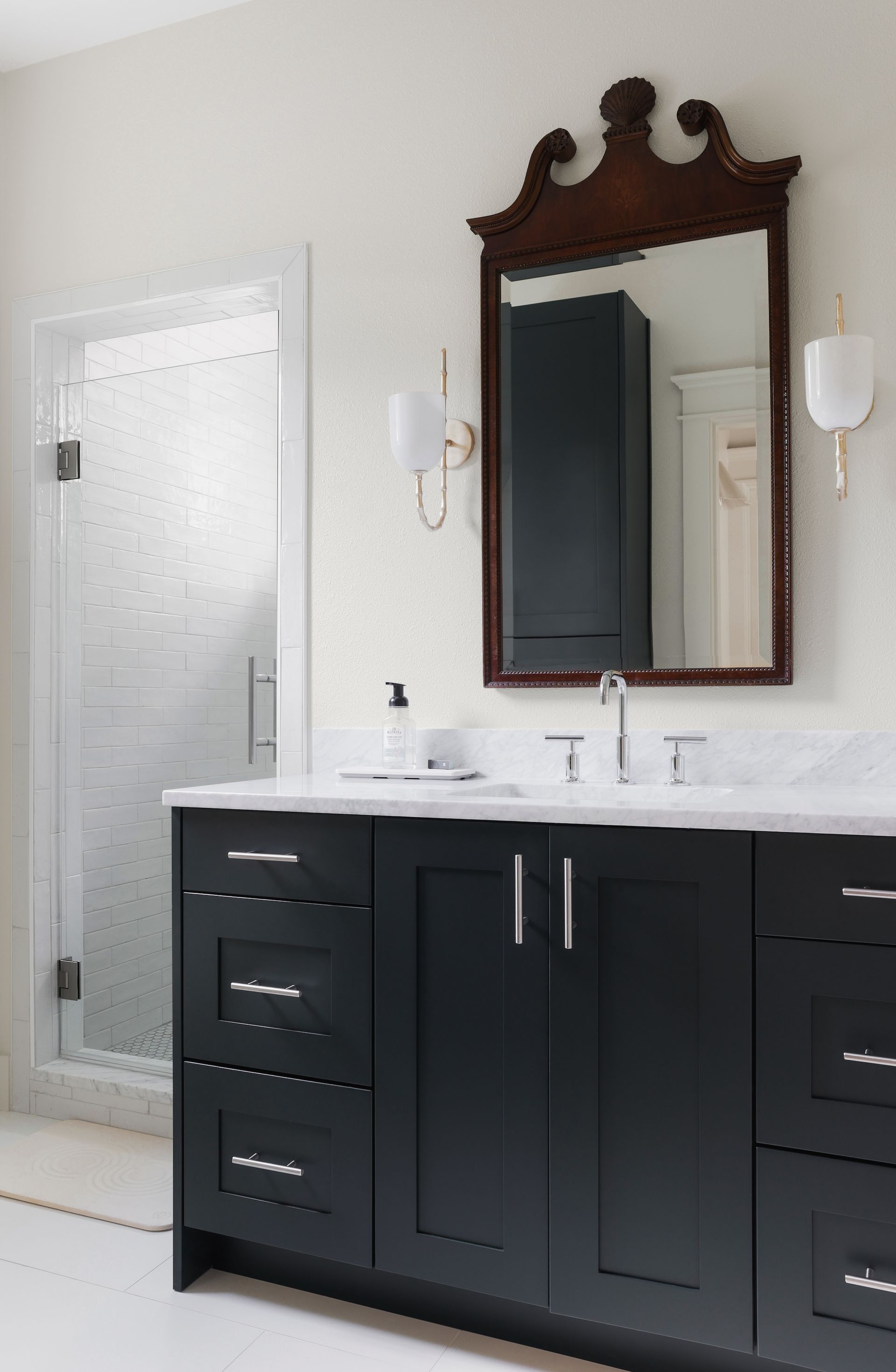 A bathroom with black cabinets and a large mirror