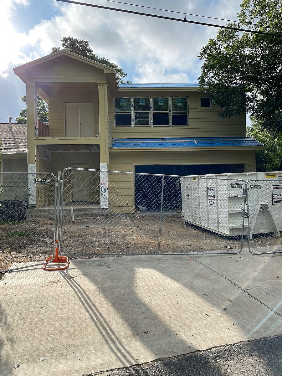 A house that is being remodeled is sitting on the side of the road.