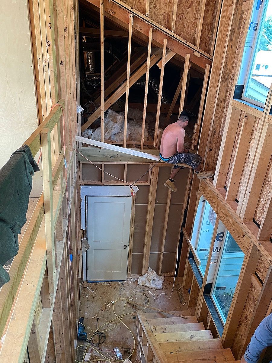 A man is sitting in the attic of a house under construction.