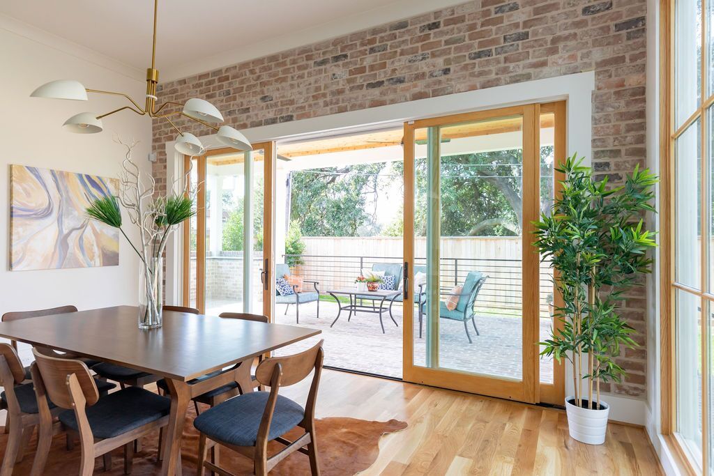 A dining room with a table and chairs and sliding glass doors leading to a patio.