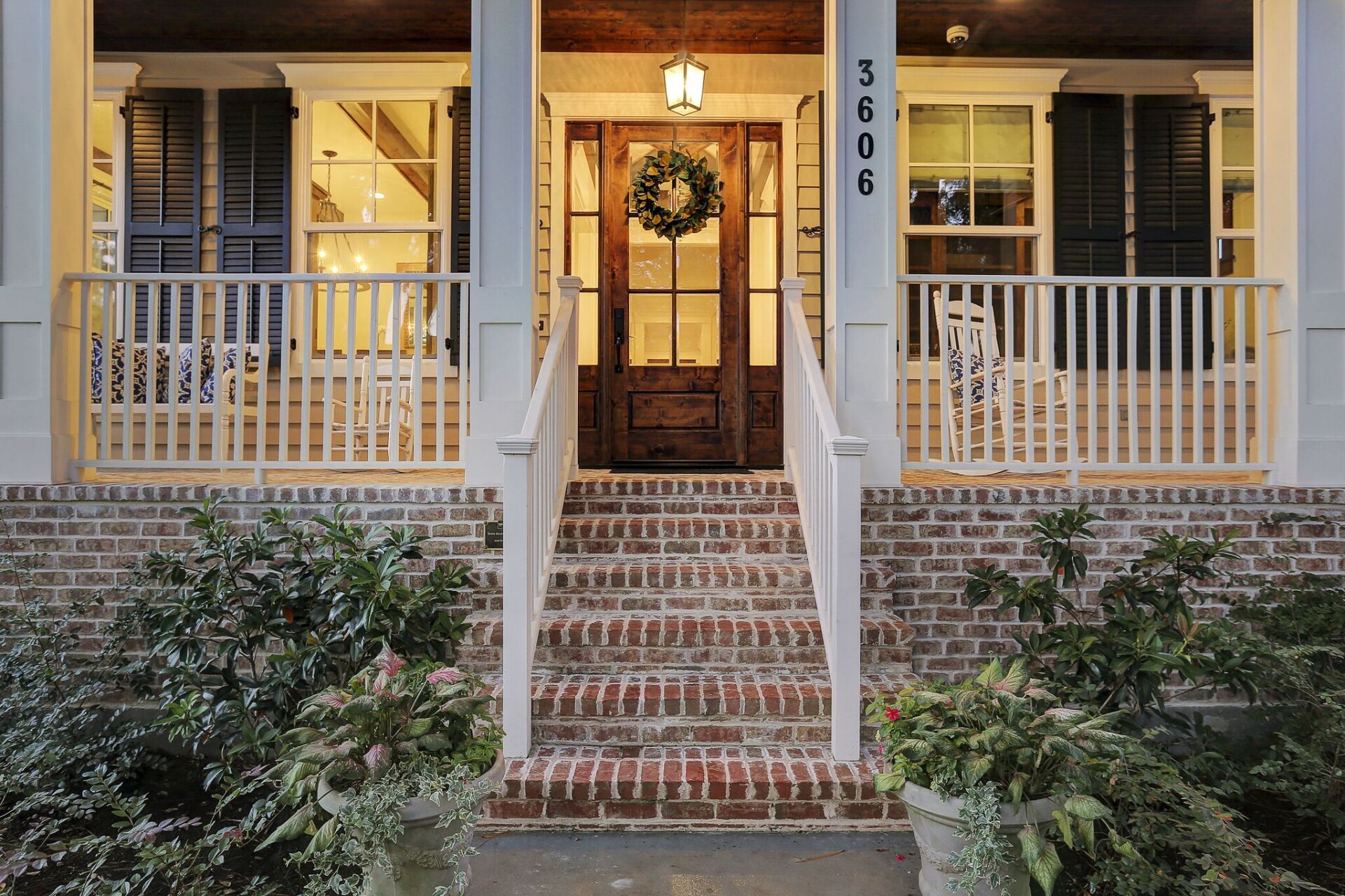 The front porch of a house with a wreath on the door.