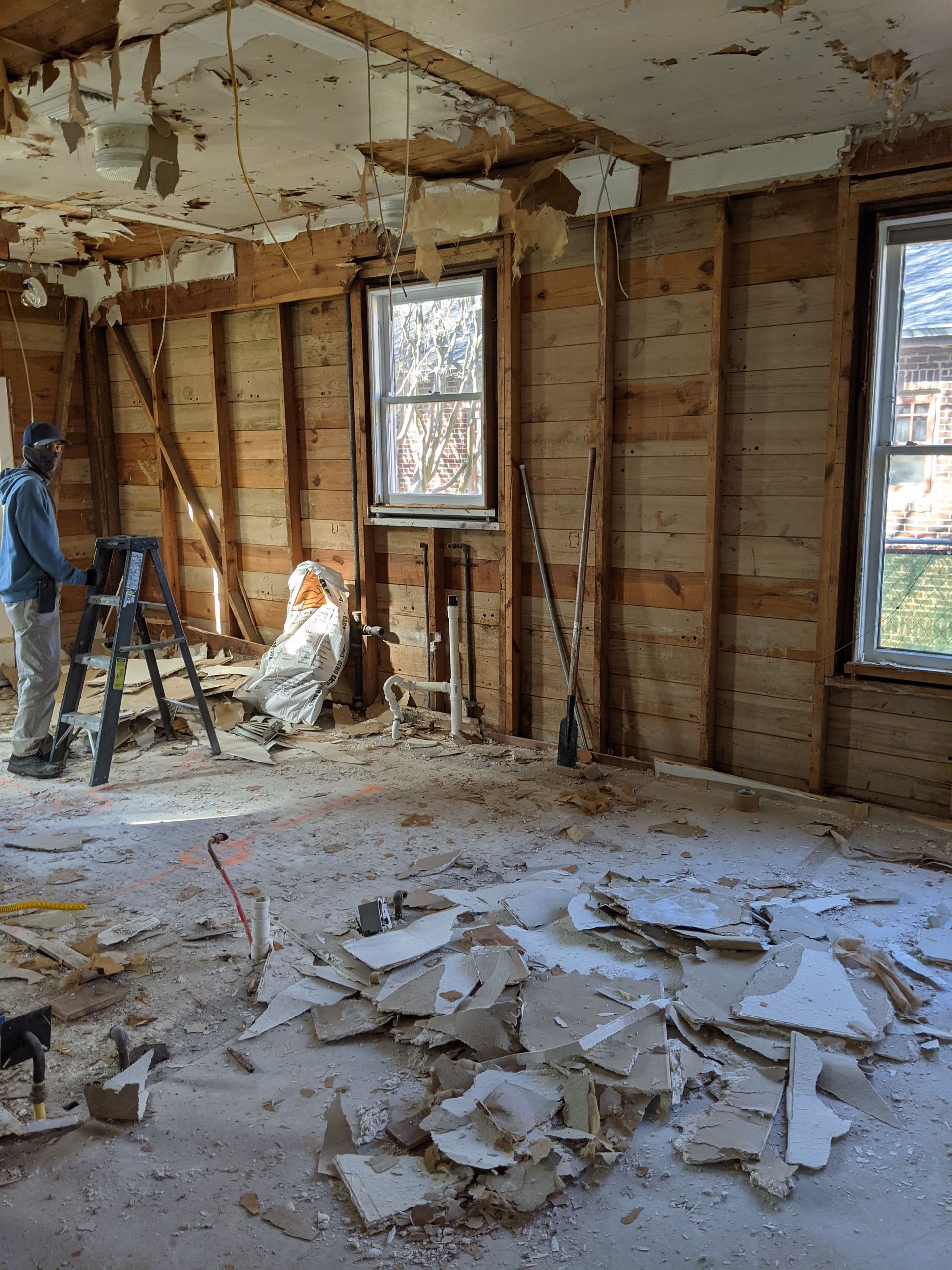 A man is standing in a room that is being remodeled.
