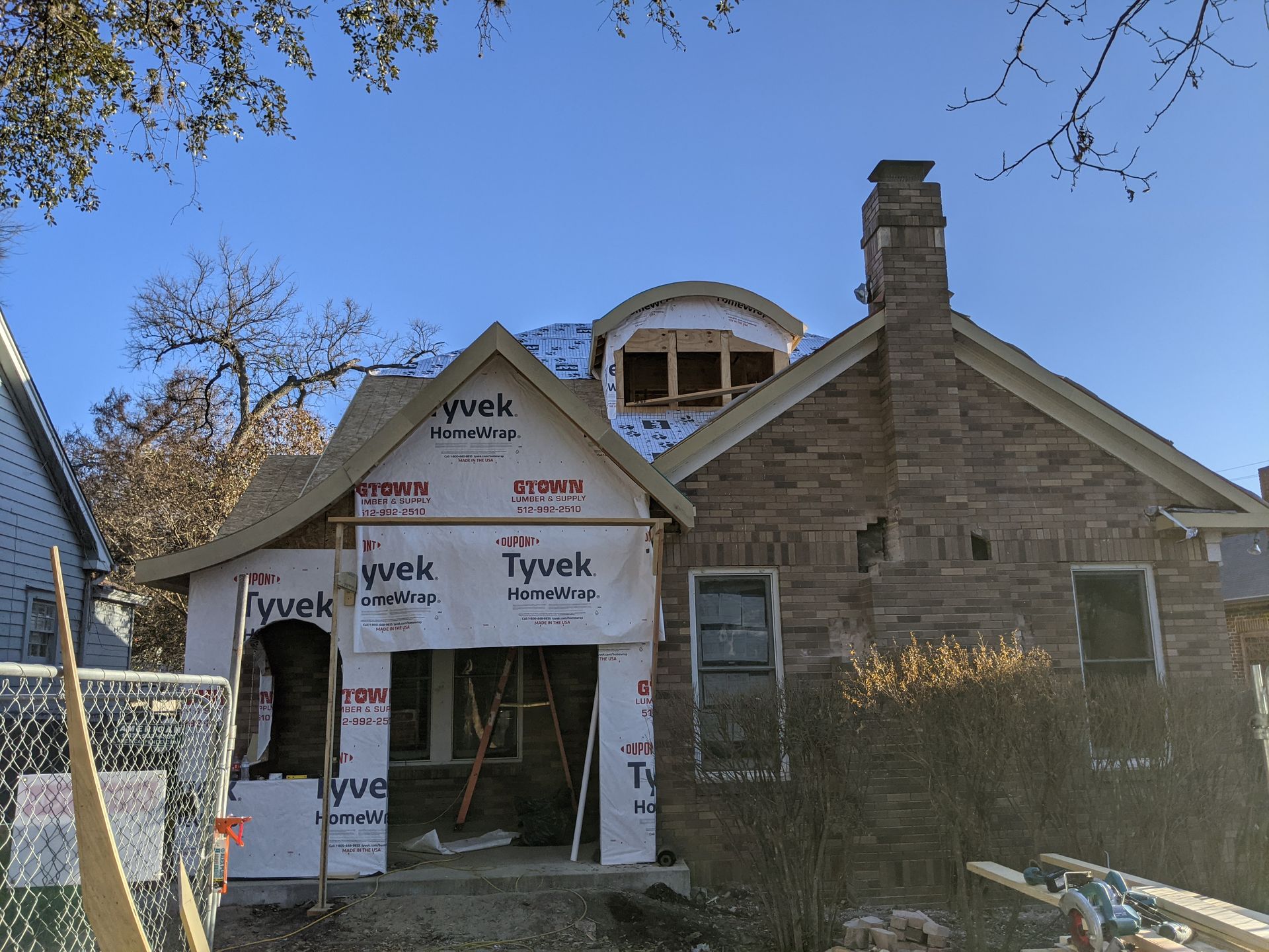 A brick house with a roof that is being remodeled