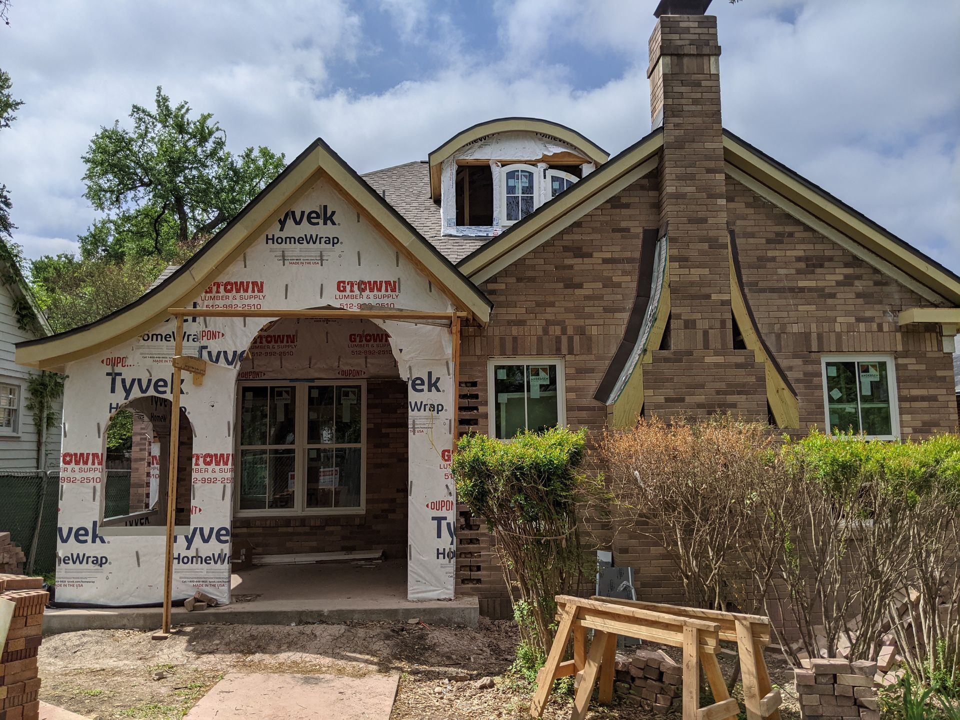 A brick house is being remodeled with a curved roof