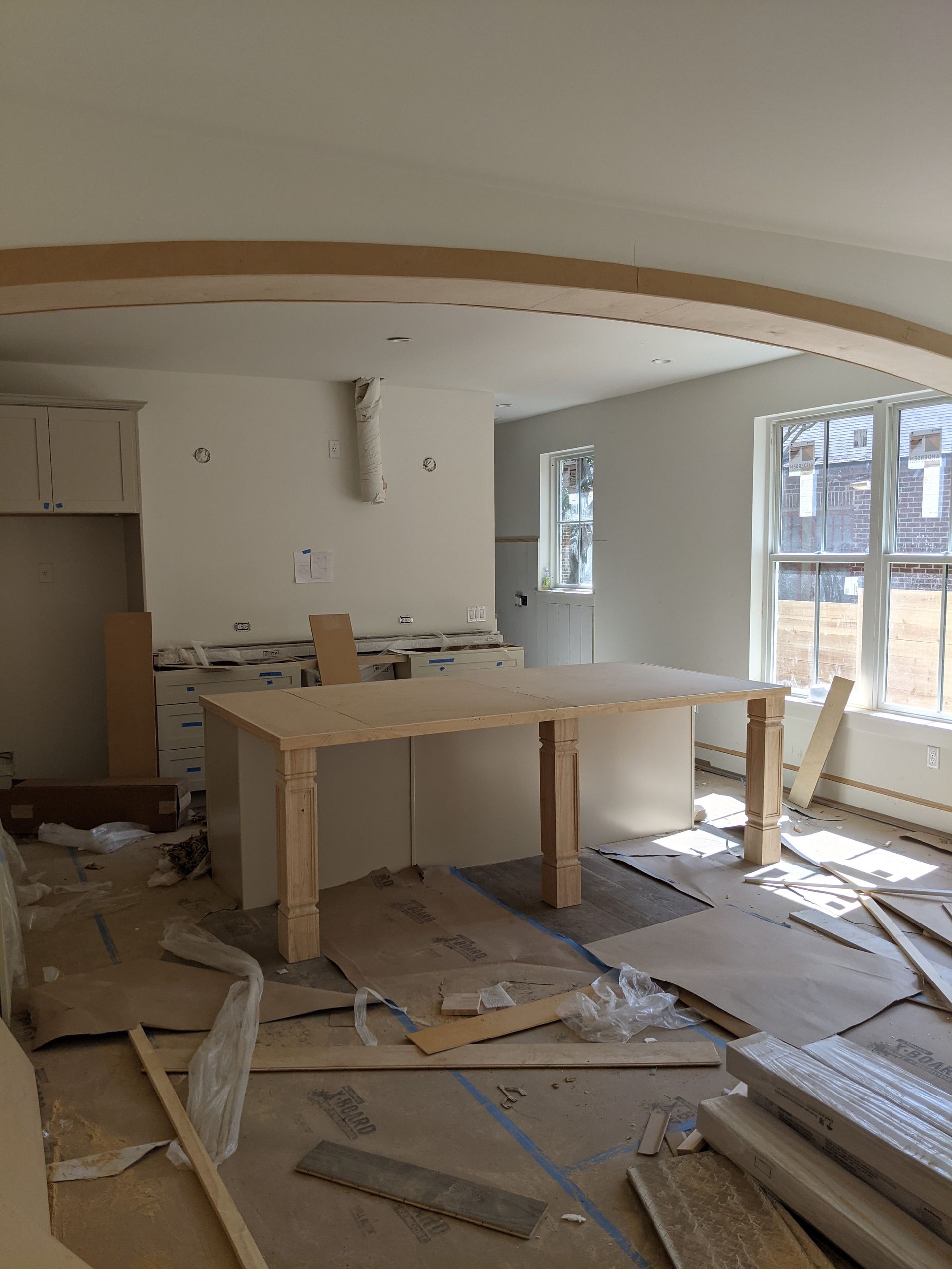 A room with a table in the middle of it and a lot of windows.