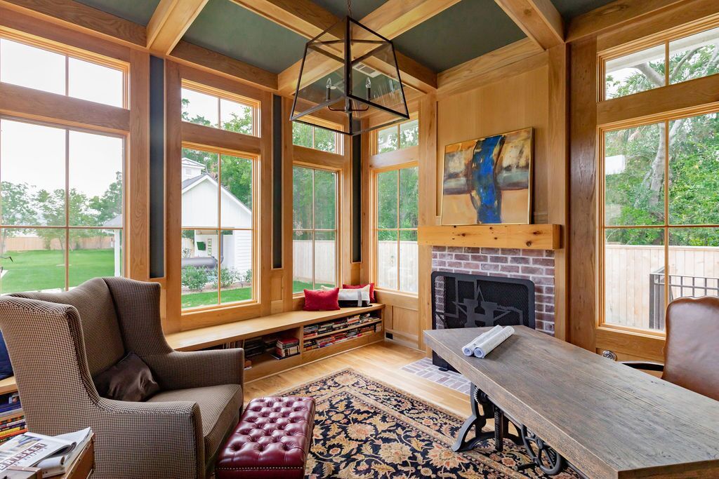 A living room with a fireplace and lots of windows
