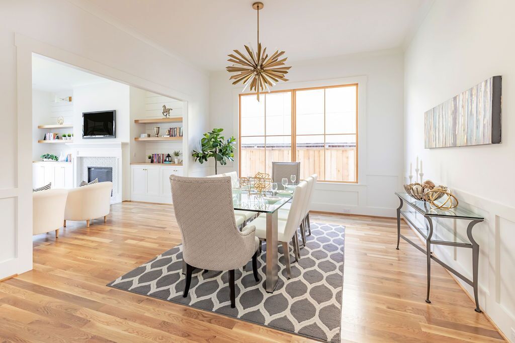 A dining room with a table and chairs and a rug.