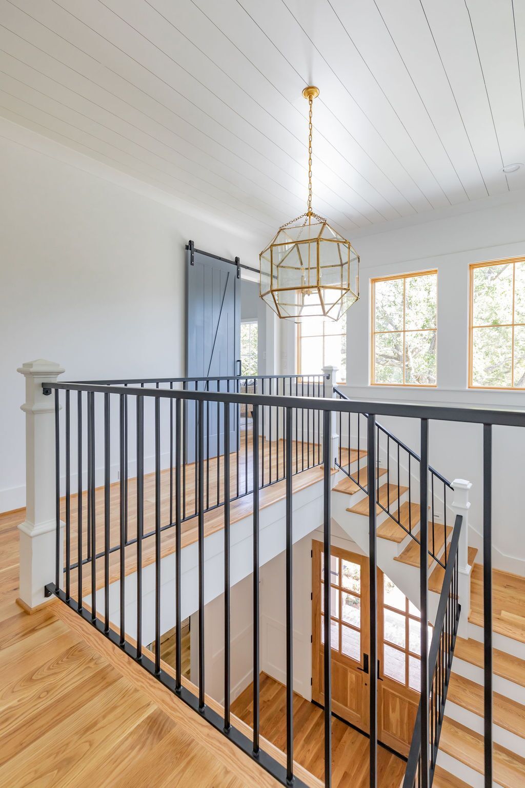 A staircase with a black railing and wooden steps