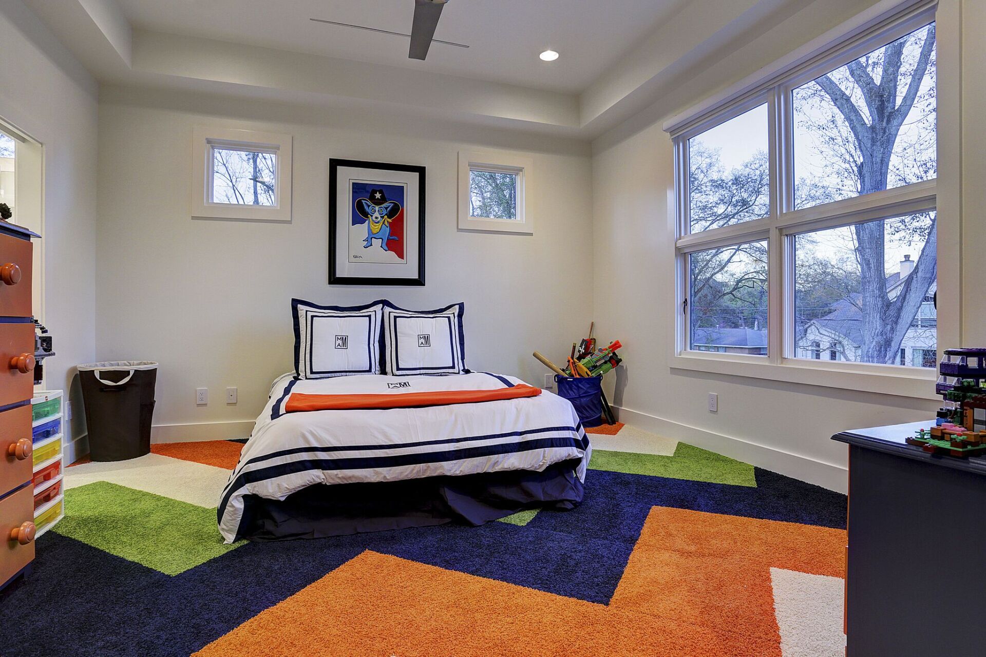 A bedroom with a bed , dresser , and window.