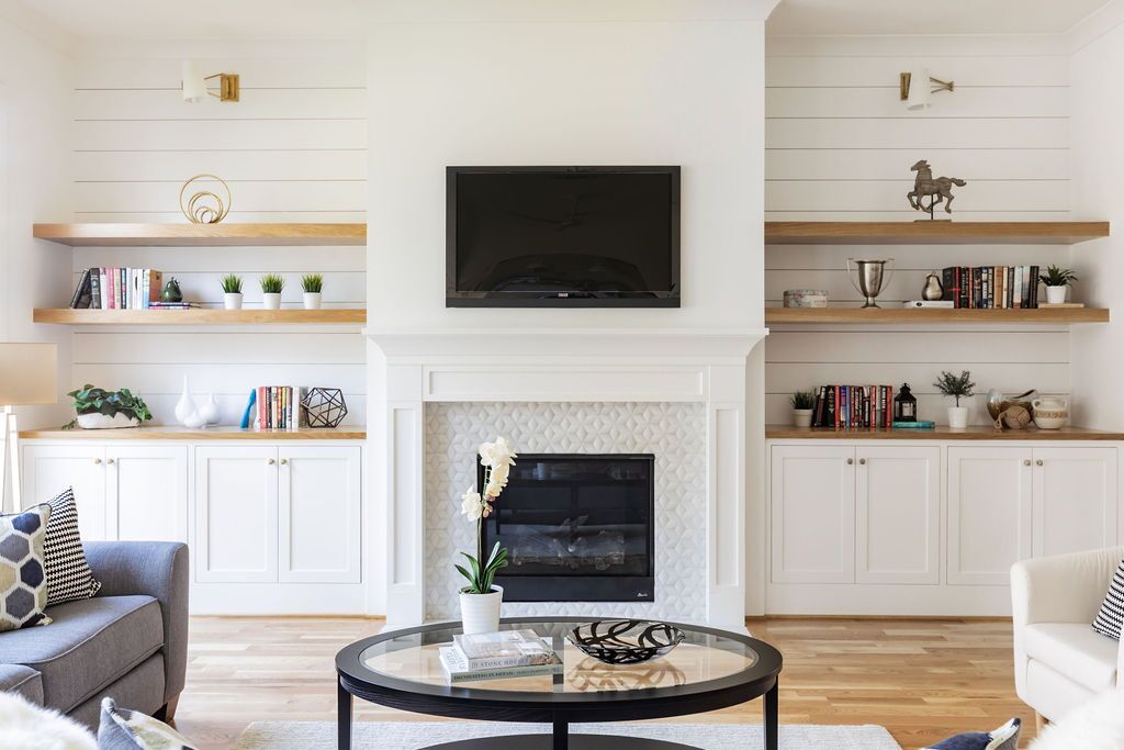 A living room with a fireplace , couch , coffee table and television.