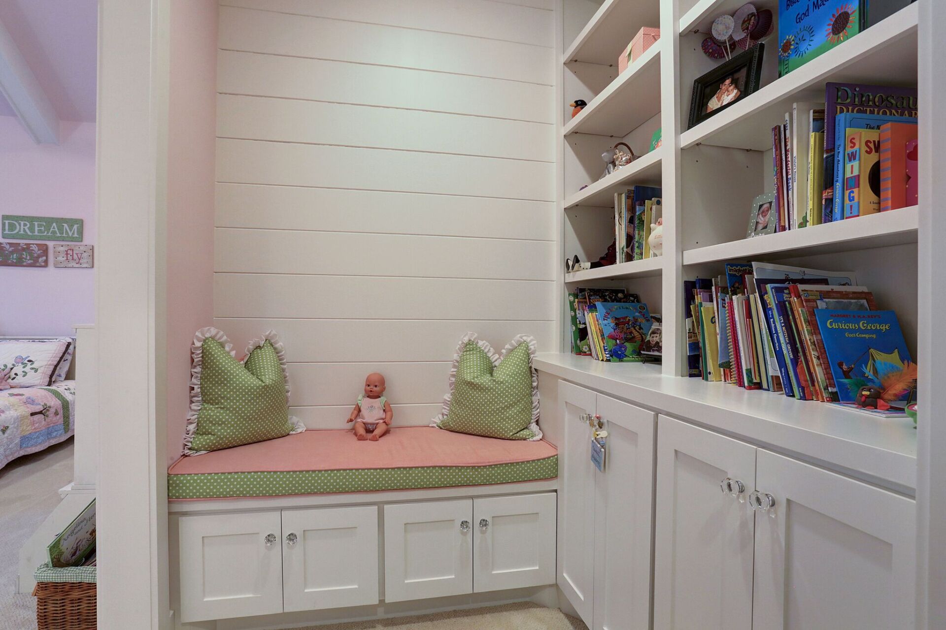 A room with a bench and shelves filled with books.