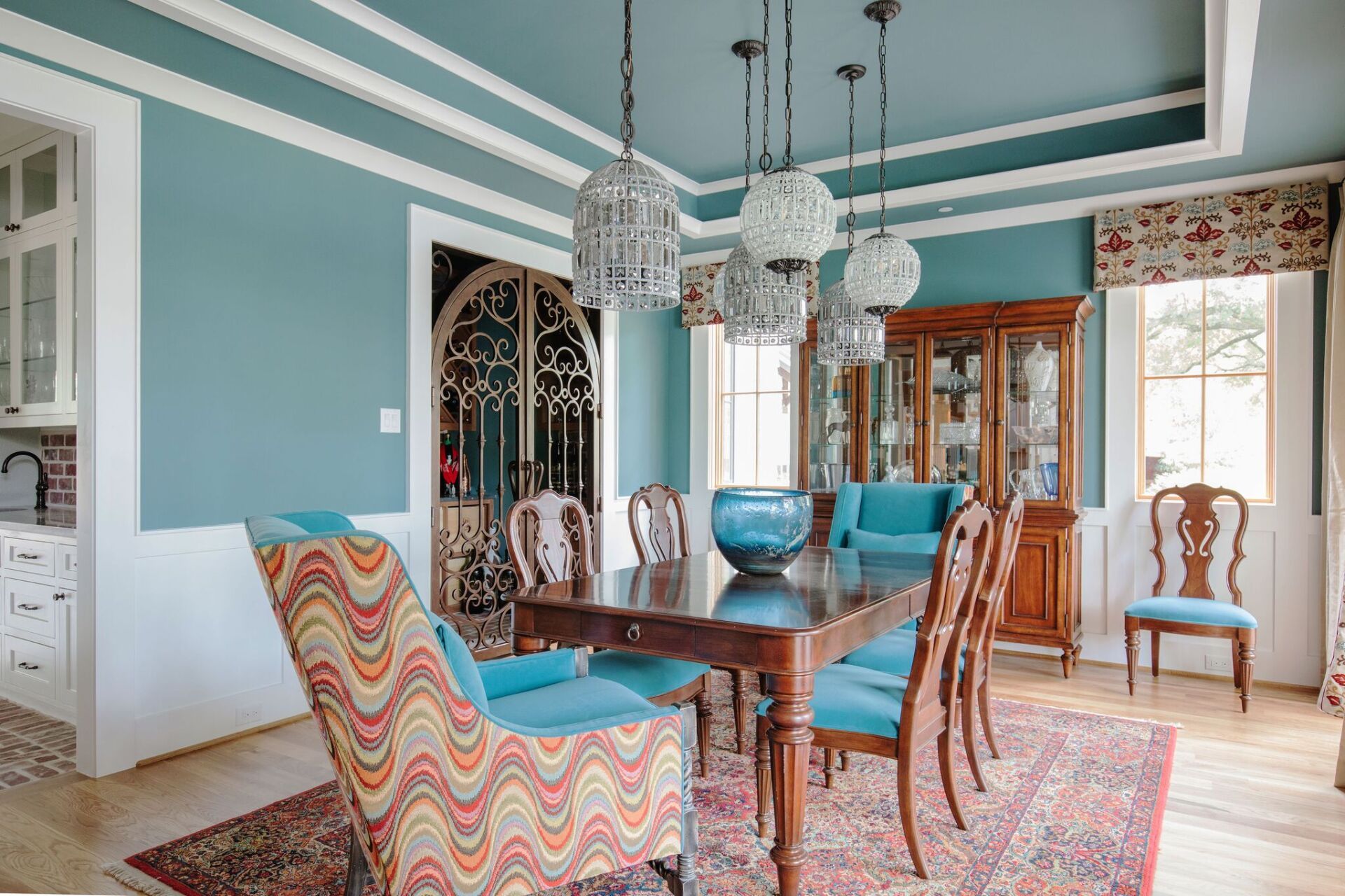 A dining room with a table and chairs and a rug.
