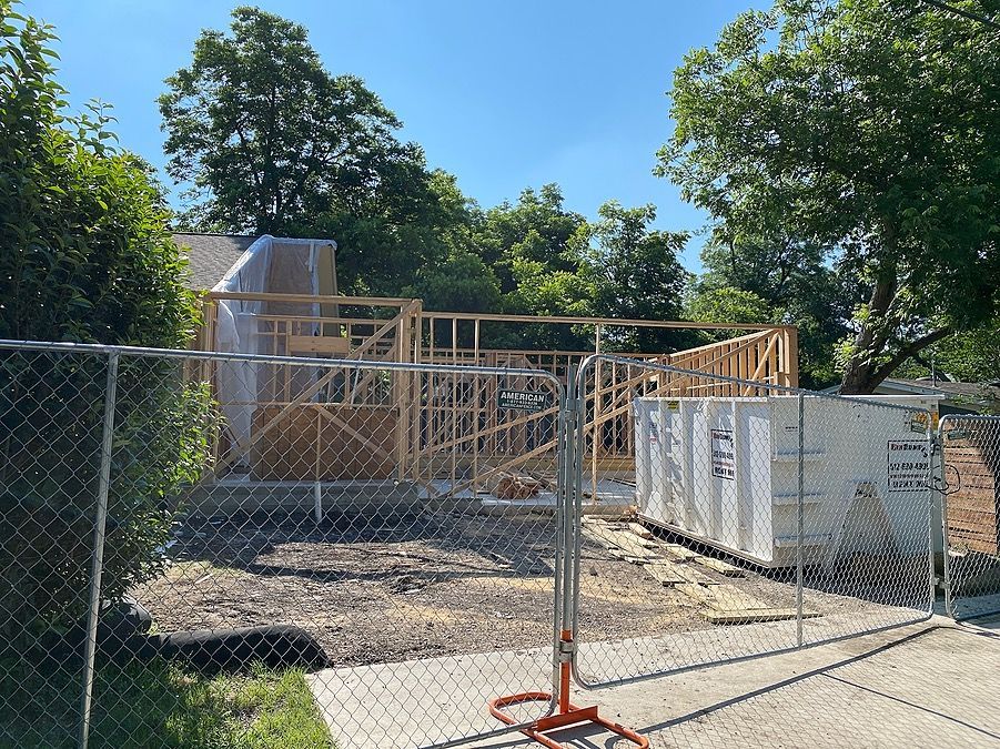 A chain link fence surrounds a building under construction.