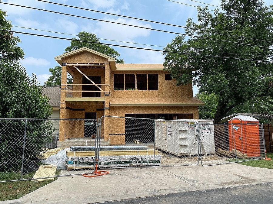 A house that is being built with a fence around it.