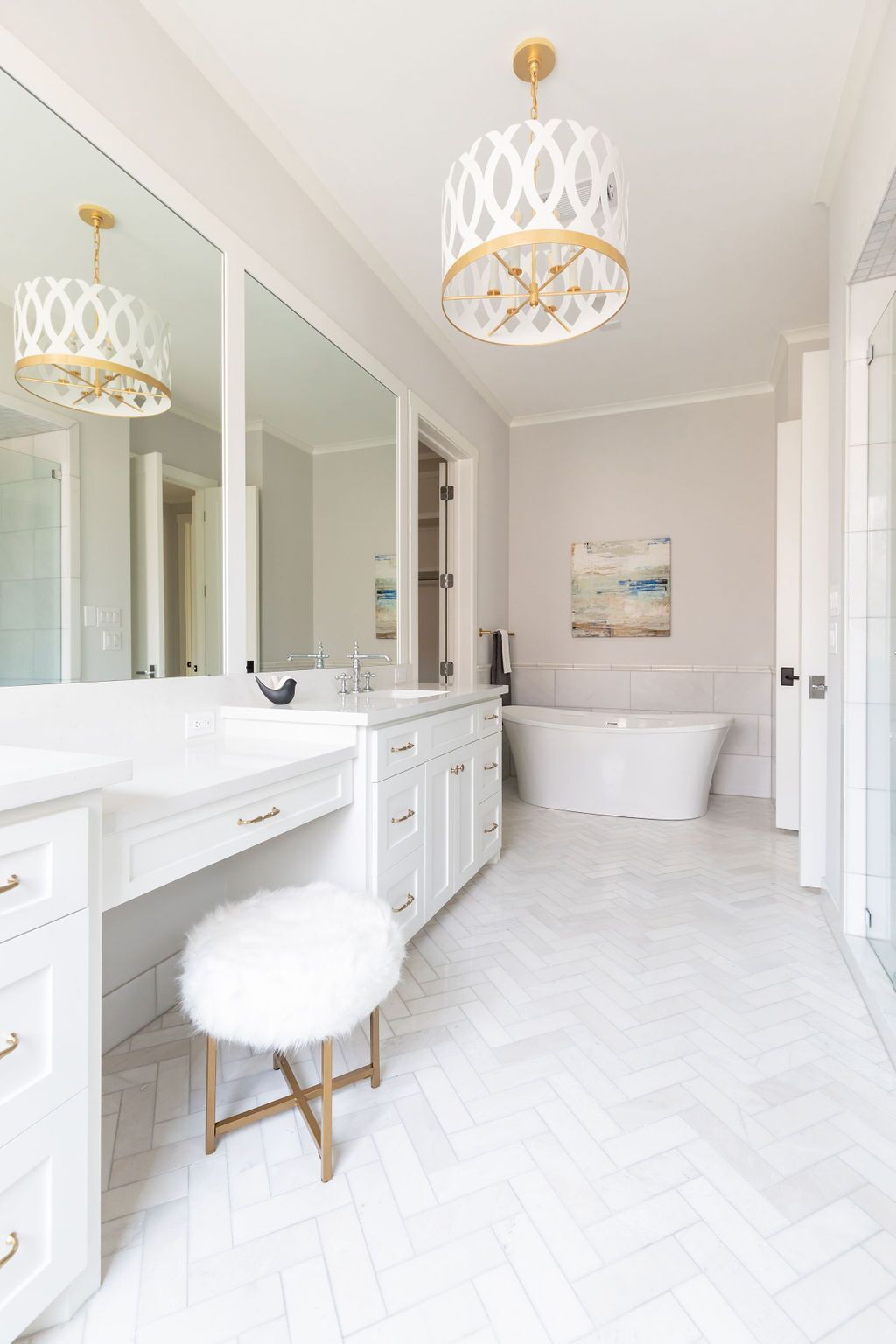 A bathroom with a bathtub , vanity , mirrors and a stool.