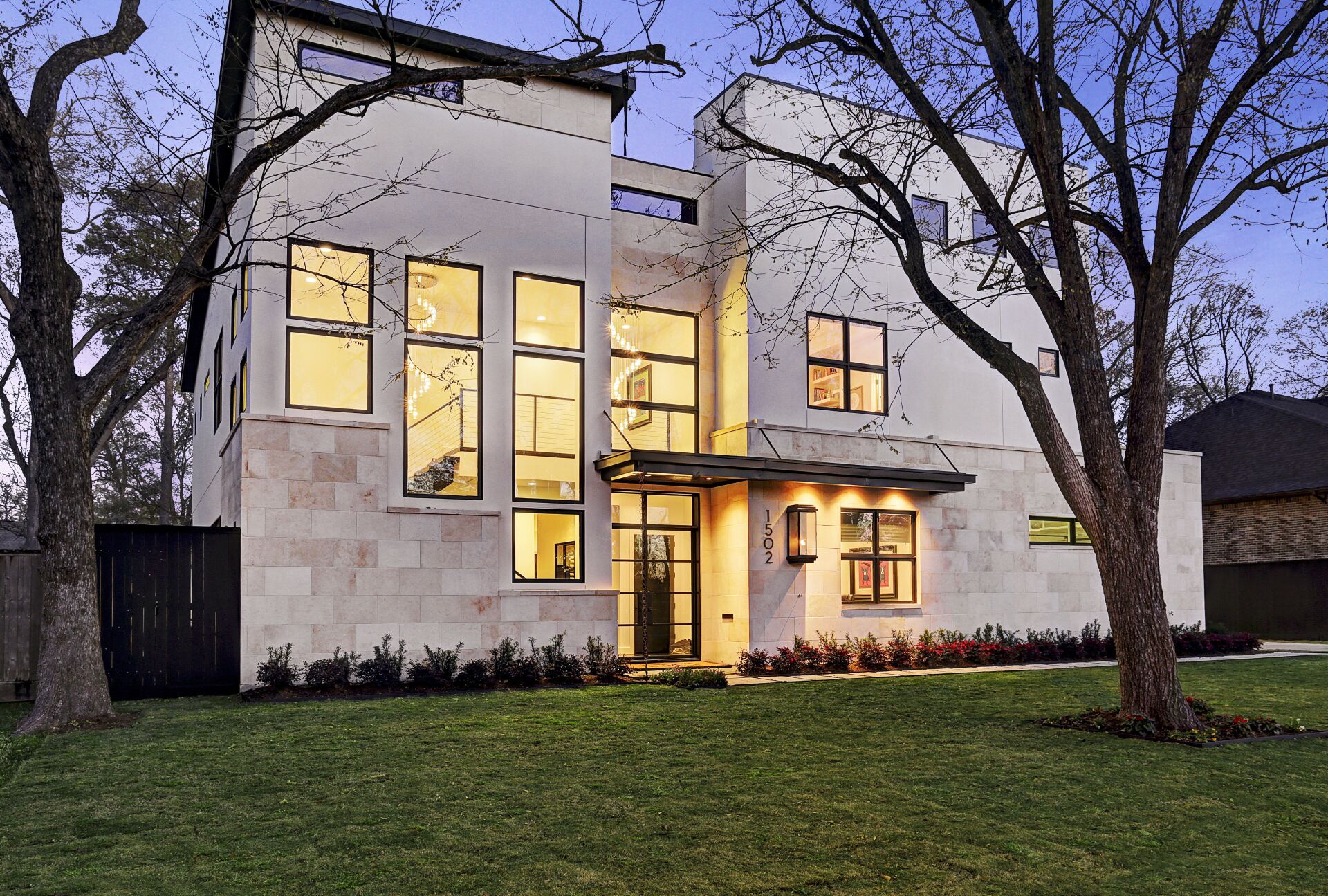 A large white house with lots of windows and trees in front of it