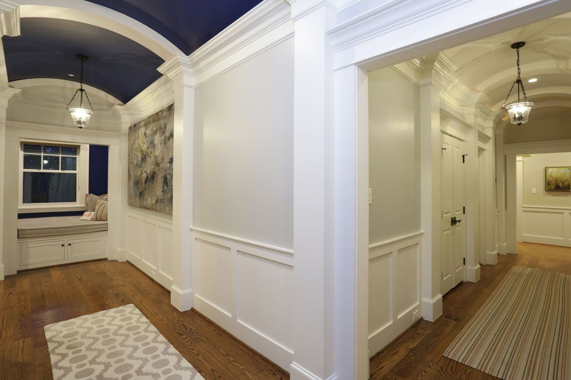 A hallway in a house with white walls and a blue ceiling.