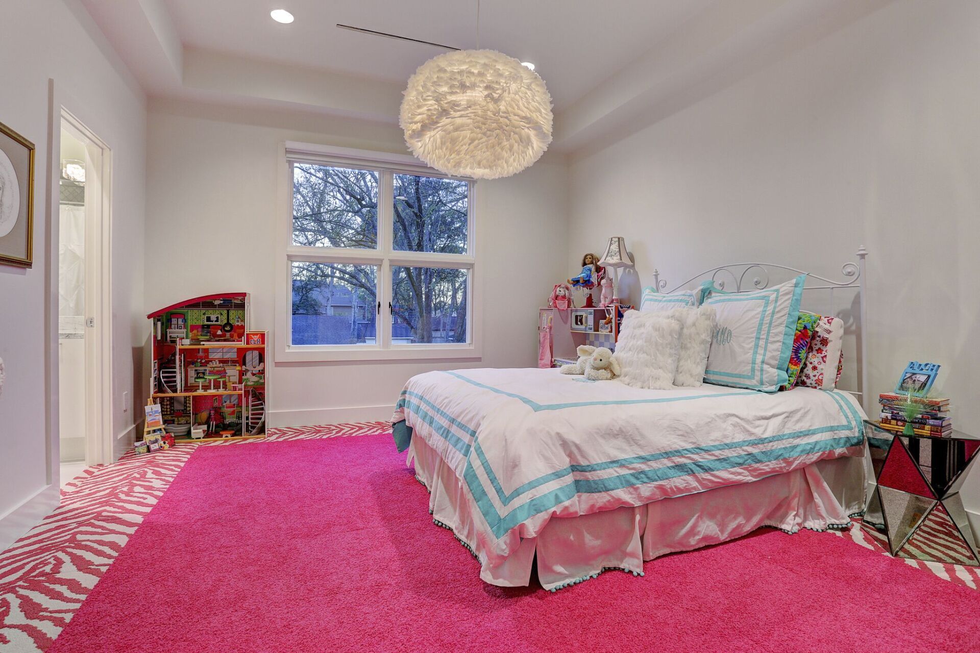 A bedroom with a bed and a pink rug.