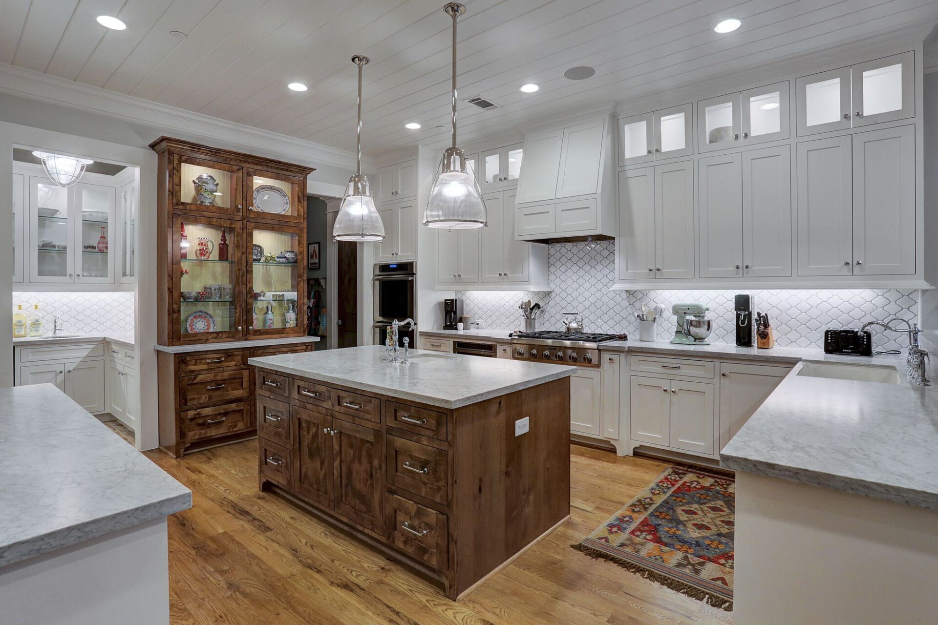 A kitchen with white cabinets and a large island in the middle.