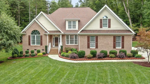 A large brick house with white trim and brown shutters