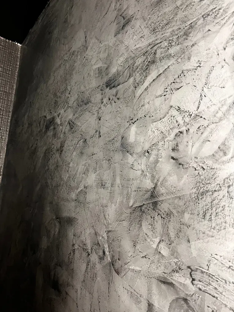 Textured wall with gray and black paint, creating a marbled effect.