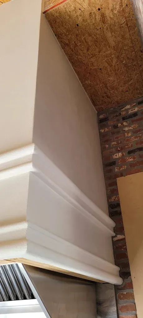 White trim installed on a wall with brick and wood surfaces.