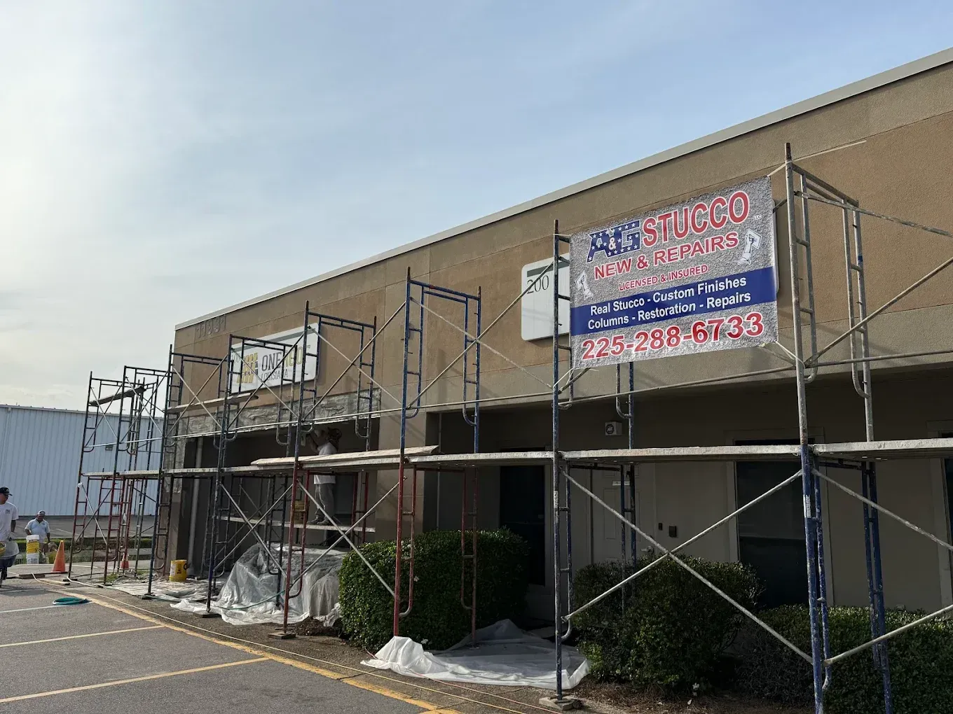 Building facade undergoing renovation with scaffolding and a contractor's sign.