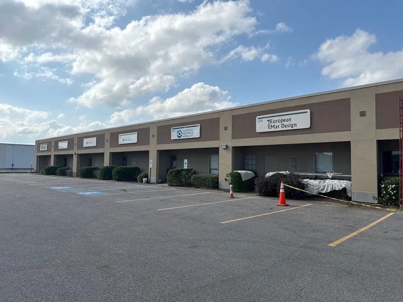 A row of single-story commercial buildings with signs on a sunny day.