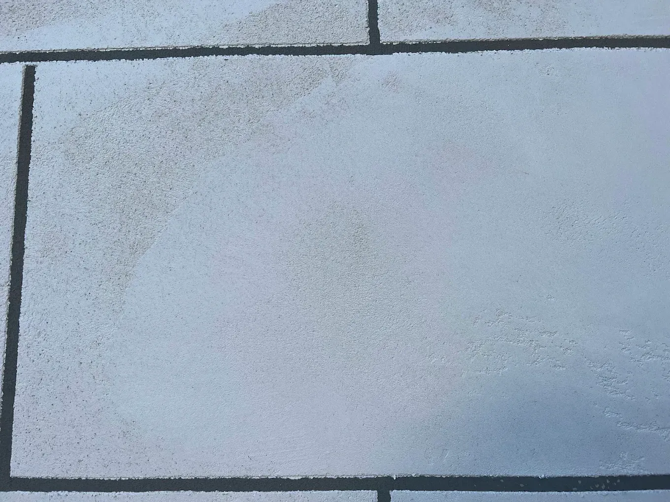 Bricks with a light-colored surface, possibly dusted with snow or frost.