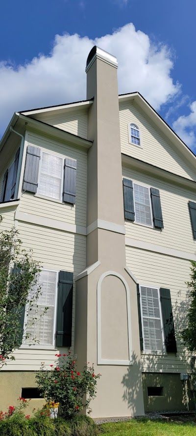 A large white house with black shutters and a chimney.